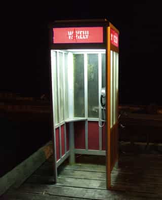 An edited photo of a phone booth with the company name "Wakely Dev" added to the top of the booth.